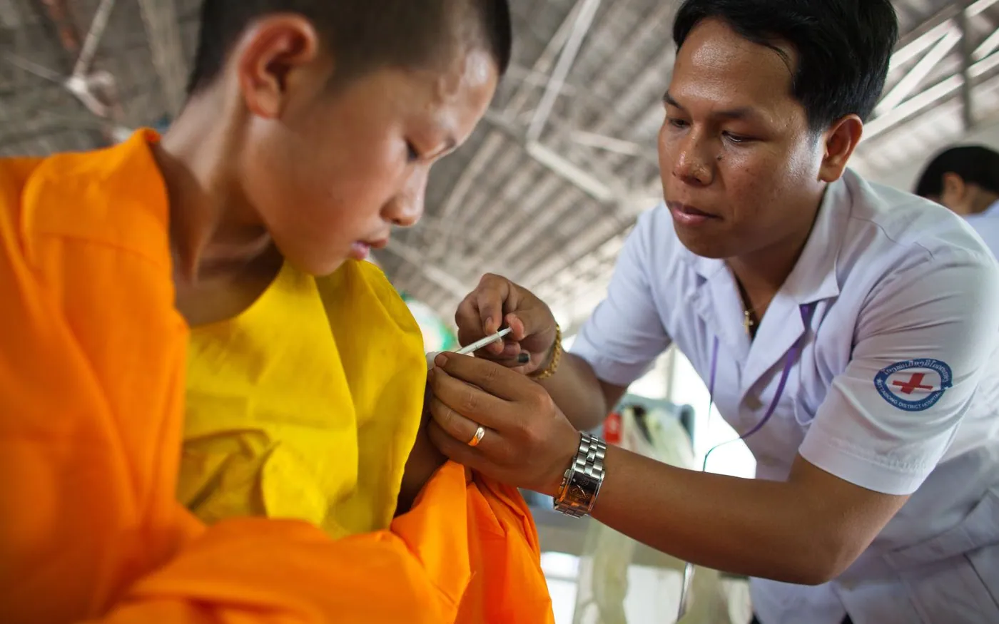 Nhân viên y tế tiêm vắc xin cho một bé trai châu Á