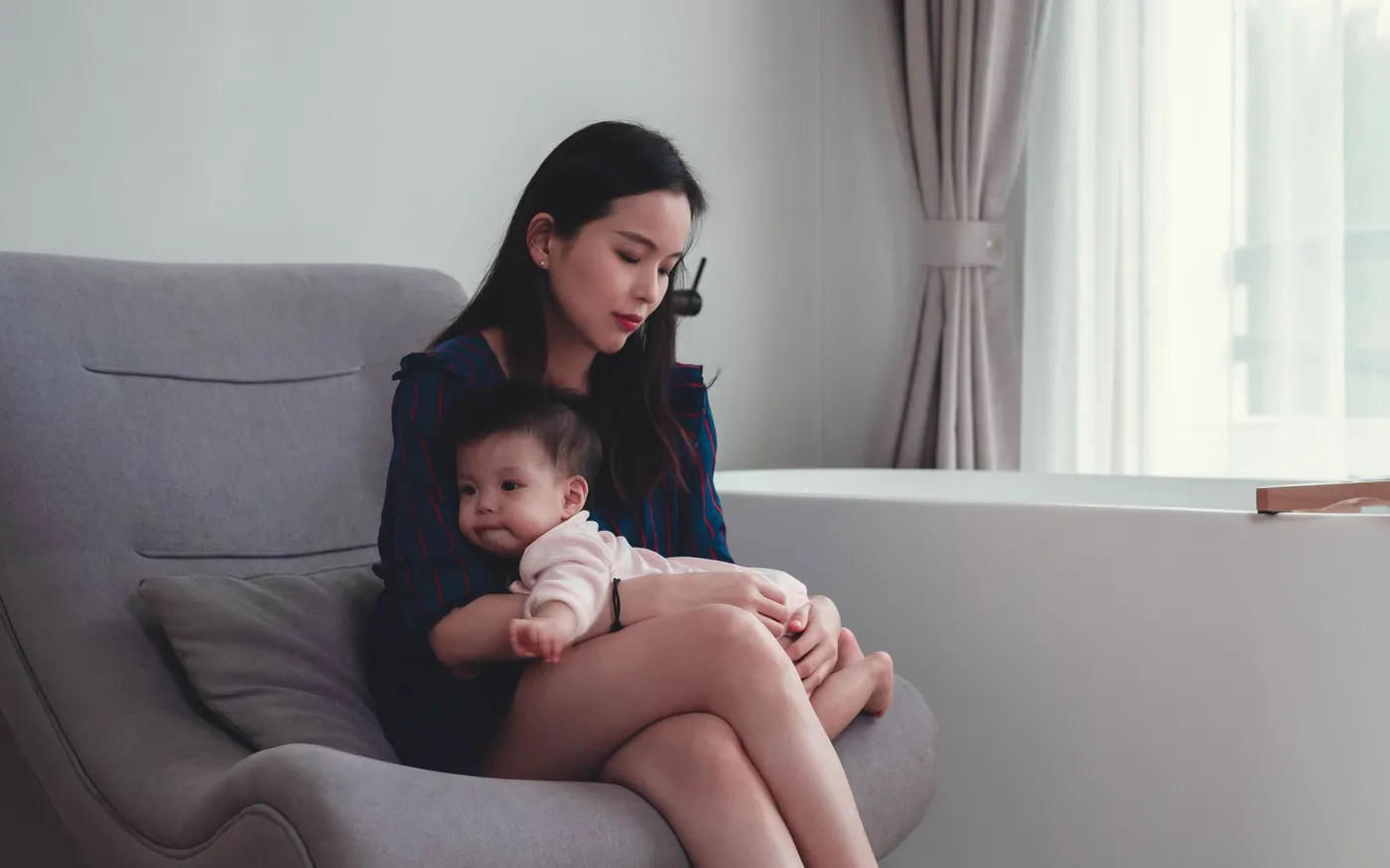 Một người mẹ châu Á ngồi yên cùng em bé