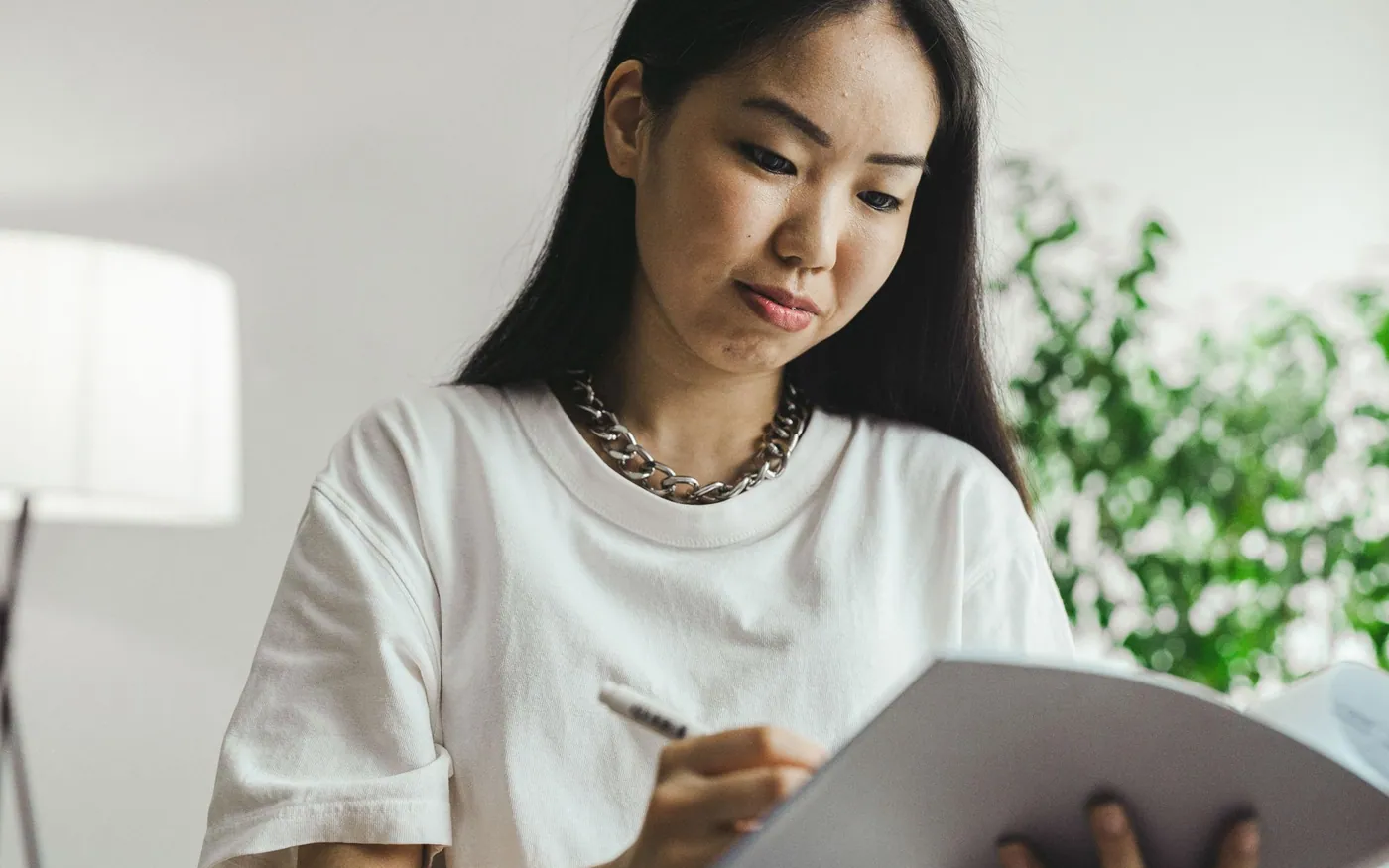 Một phụ nữ châu Á viết kế hoạch vào sổ