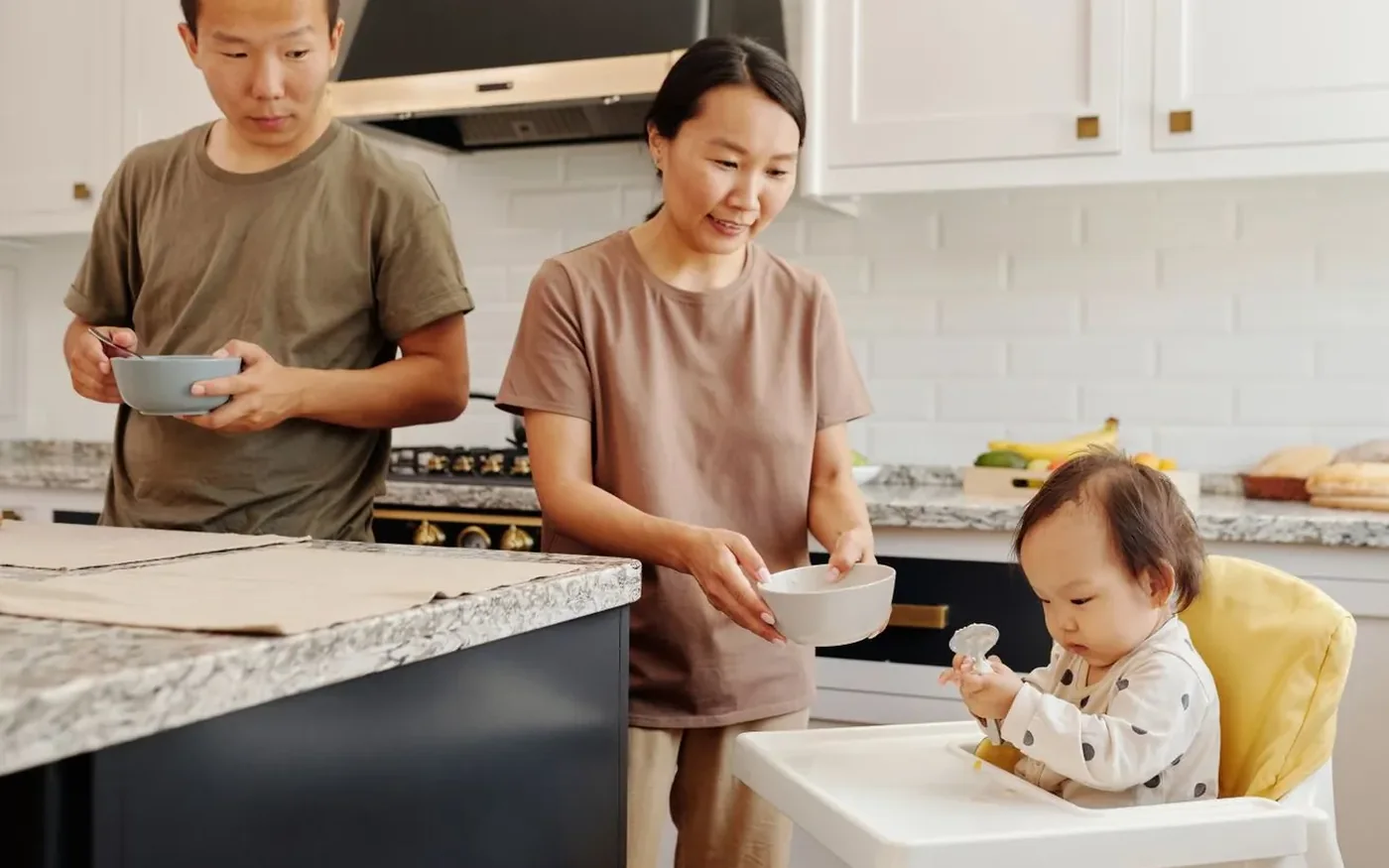Gia đình châu Á chuẩn bị bữa ăn cho em bé