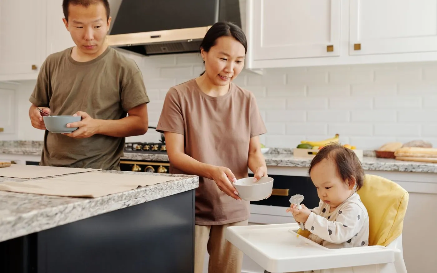 Gia đình châu Á chuẩn bị bữa ăn cho em bé