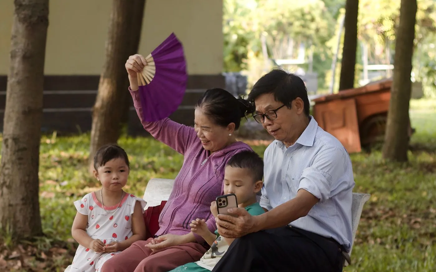 Một gia đình Việt Nam nghỉ dưới bóng cây ở công viên