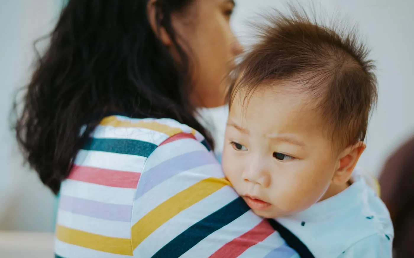Một người mẹ châu Á ôm em bé