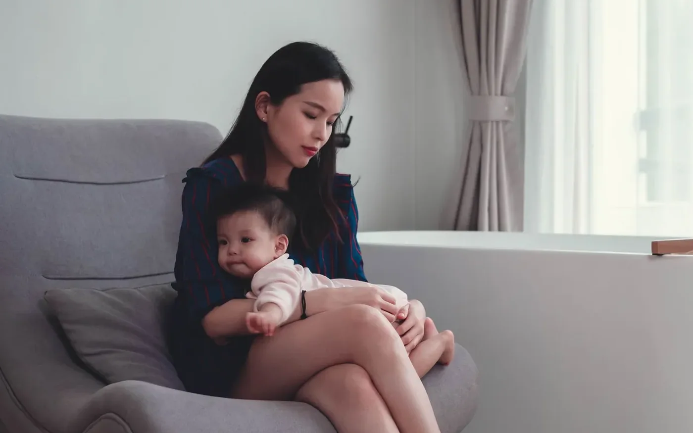 Một người mẹ châu Á ngồi yên cùng em bé