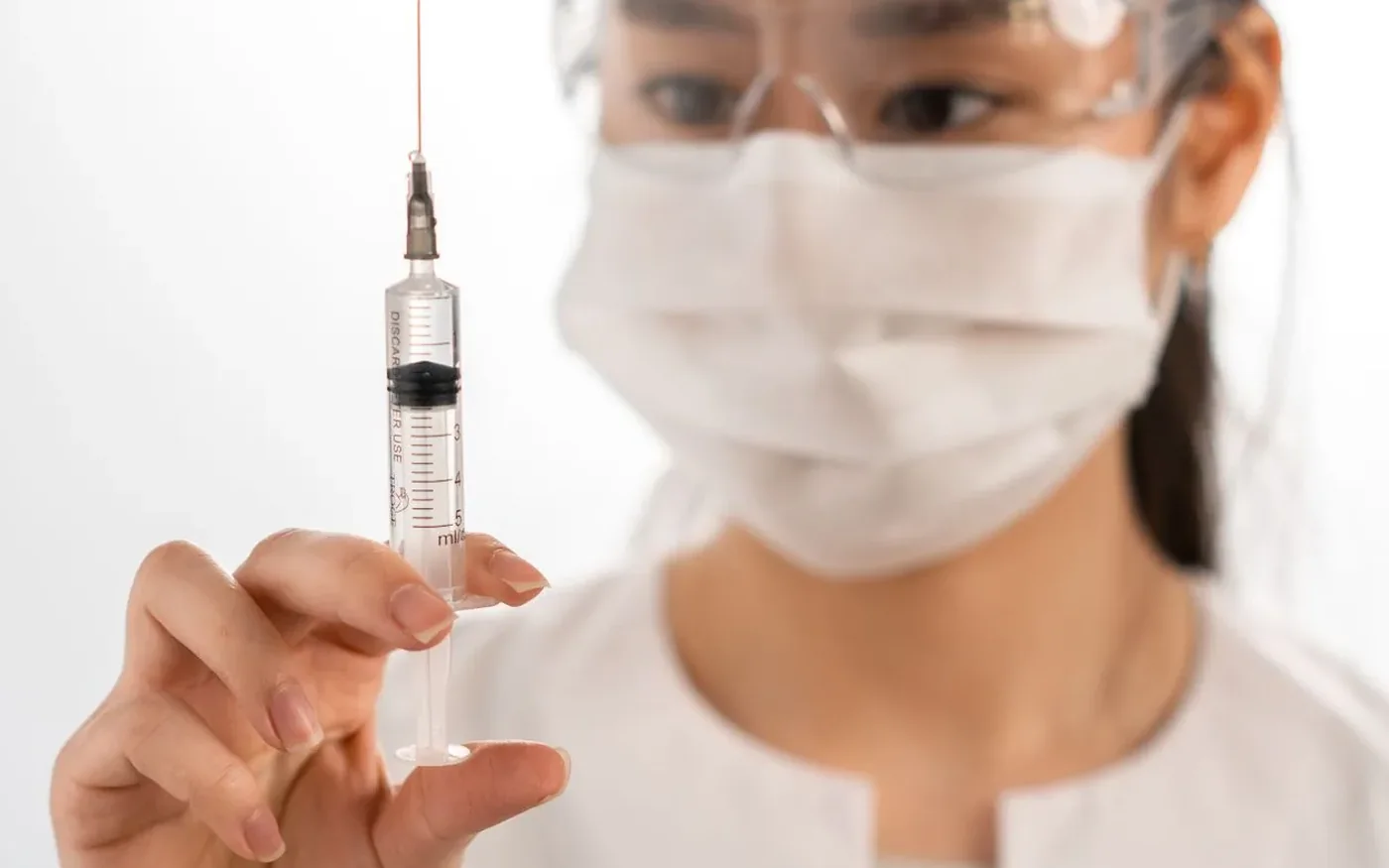 Nữ nhân viên y tế châu Á chuẩn bị một mũi tiêm