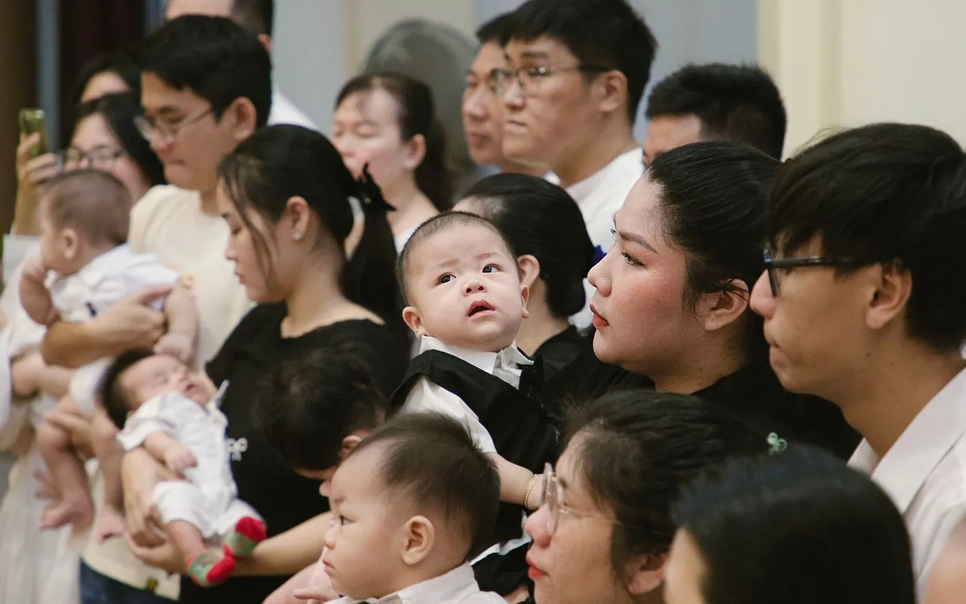 Các gia đình Việt Nam bế em bé trong một buổi lễ