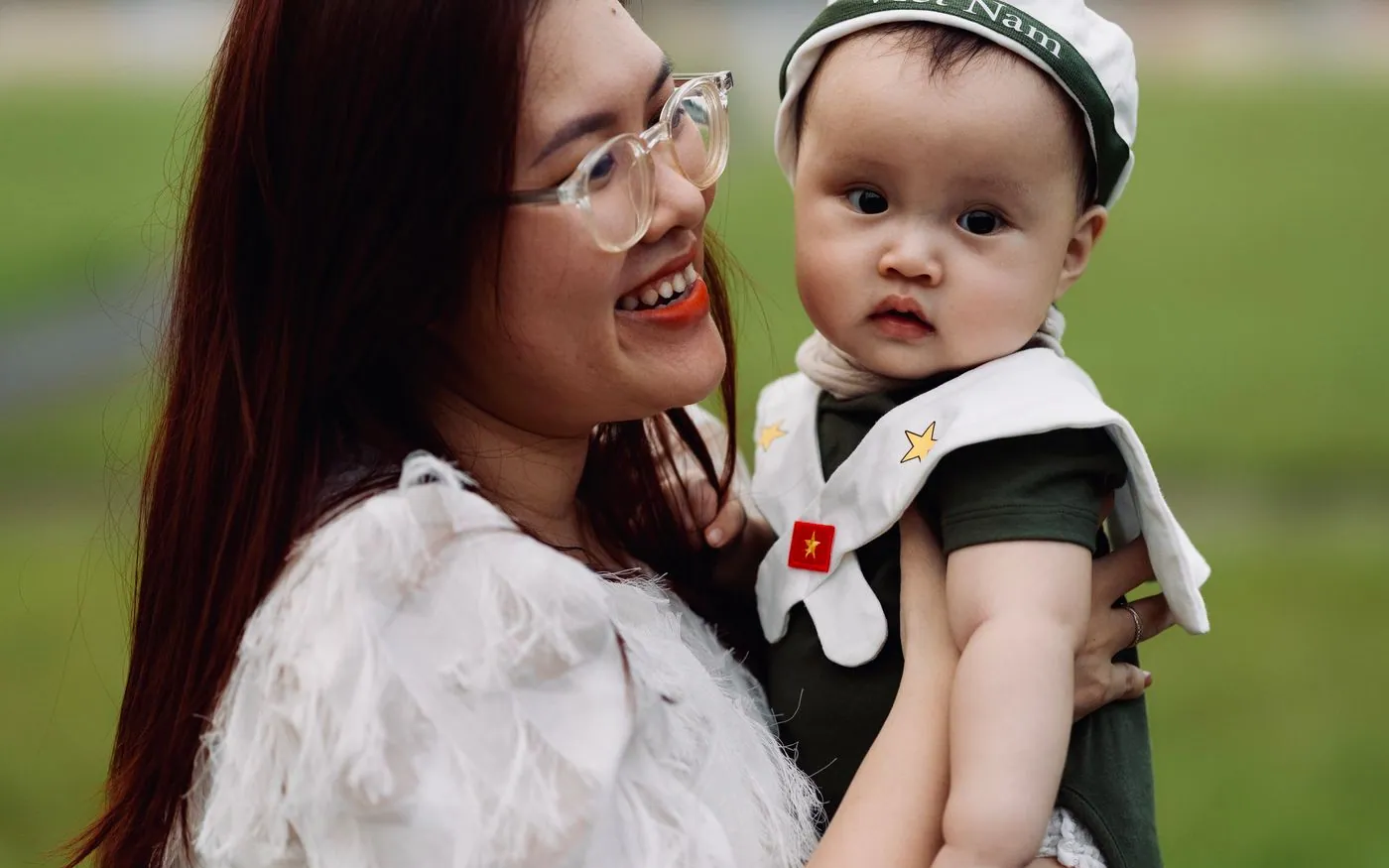 Một người mẹ Việt Nam bế em bé ngoài trời